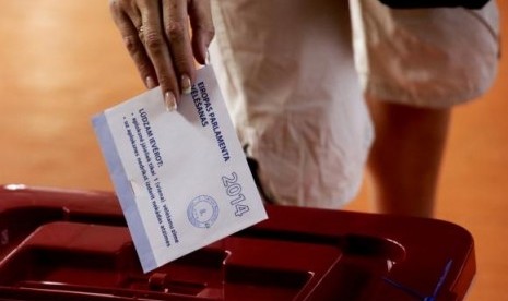 A woman casts her vote during European Parliament elections in Riga May 24, 2014.