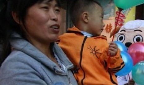 A woman holds her child on a street in Beijing, China. (File photo)