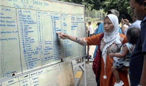 A woman looks for her family member on the list of victims in Bahuga Jaya accident on Wednesday. (file photo)  