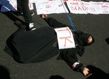 A woman plays dead in a protest that demands the government to put some restriction in sending Indonesian workers abroad. (photo file)  