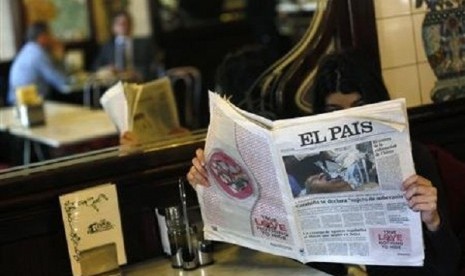 A woman poses with a copy of the January 24 first edition of Spanish newspaper El Pais in a cafe in central Madrid January 24, 2013. 