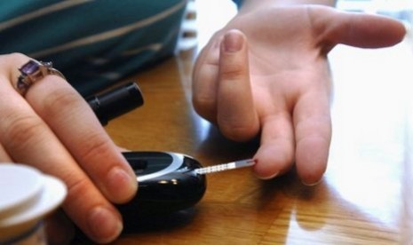 A woman tests her blood sugar level as part of her management of diabetes. 