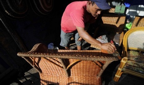 A worker furnishes rattan chair in a workshop in Jakarta. (Illustration)