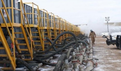 A worker monitors water tanks at a Hess fracking site near Williston, North Dakota November 12, 2014. 