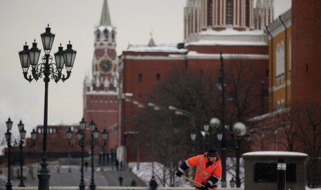 A worker shovels snow, with the Kremlin seen in the background, in central Moscow, Russia. (file photo)