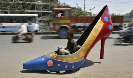 A worker test drives a car in the shape of a heels on a road in the southern Indian city of Hyderabad March 7, 2012. The shoe is part of a ladies series of creations by Indian car designer Sudhakar Yadav to mark the International Women's Day and the car ca