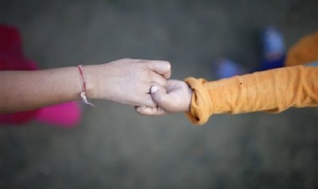 A young HIV patients hold hands as she plays at the Saphalta HIV Shiksya Sadan School, in Kirtipur, near Katmandu, recently.  