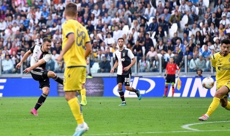 Aaron Ramsey (kiri) mencetak gol saat Juventus melawan Verona, Ahad (22/9) dini hari