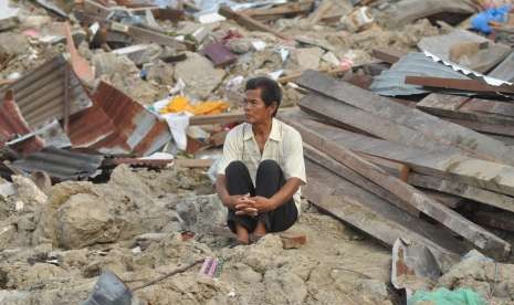 Abdullah (64), salah satu korban selamat dari bencana alam gempa dan pencairan tanah (likuifaksi) duduk disekitar puing rumahnya yang hancur dan tertimbun lumpur di Kelurahan Petobo, Palu, Sulawesi Tengah, Kamis (11/10).