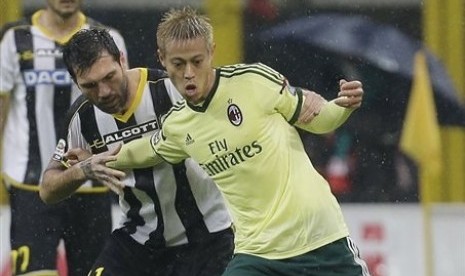 AC Milan's Keisuke Honda, right, challenges for the ball with Udinese's Maurizio Domizzi In Milan, Nov 30, 2014. 