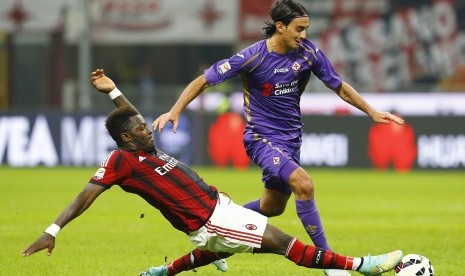 AC Milan's Sulley Muntari (L) challenges Fiorentina's Alberto Aquilani during their Serie A soccer match at San Siro stadium in Milan, October 26, 2014.