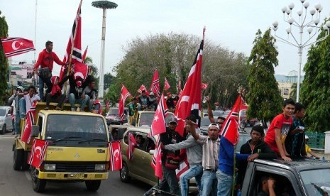 Acehnese bring local flag (crescent and mood) or Qanun and demand the central government to officially adopt it.  