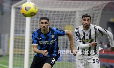  Achraf Hakimi dari Inter Milan, kiri, bersaing memperebutkan bola dengan Gianluca Frabotta dari Juventus pada pertandingan sepak bola Serie A antara Inter Milan dan Juventus di stadion San Siro di Milan, Italia, Senin (18/1) dini hari WIB.