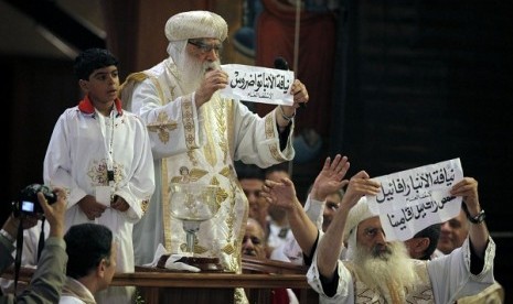 Acting Coptic Pope Pachomios, center, displays the name of 60-year-old Bishop Tawadros, soon to be Pope Tawadros II, during the papal election ceremony at the Coptic Cathedral in Cairo, Egypt, Sunday, Nov. 4, 2012.   