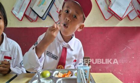 Aditya Permana (8), siswa SDN Cibungur 2 Batujajar, Kabupaten Bandung Barat (KBB), terlihat sangat senang memakan program MBG