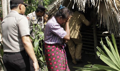 Adolfina Naonin (tengah) menangis ketika Bupati Kabupaten Kupang Ayu Titu Eki meninjau dirinya yang tinggal di kandang babi dengan seekor babi di desa Oebesi Kabupaten Kupang NTT Selasa (15/3). 