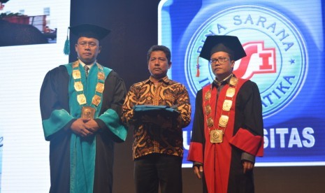 Agus Suprianto, ayah Muhammad Lutfi Naufal  (mengenakan kemeja batik) saat menggantikan putranya untuk diwisuda saat wisuda akbar UBSI yang ke-52, Senin  (25/11),  didampingi oleh Rektor UBSI, Dr Mochamad Wahyudi  (kiri).