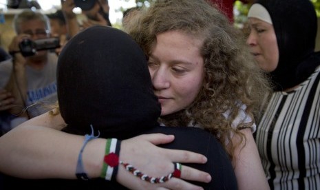 Ahed Tamimi dipeluk sanak saudaranya saat kedatangannya di Tepi Barat dekat Ramallah, Ahad (29/7). Tamimi dan ibunya dibebaskan tentara Israel setelah menjalankan delapan bulan penjara.