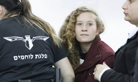 Ahed Tamimi saat digiring polisi Israel menuju pengadilan militer di  Betunia, Tepi Barat, Rabu (20/12).