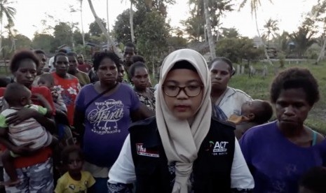 Ahli gizi kesehatan masyarakat yang menjadi relawan ACT, Harum Aulia Rahmawati bersama warga Asmat, Papua