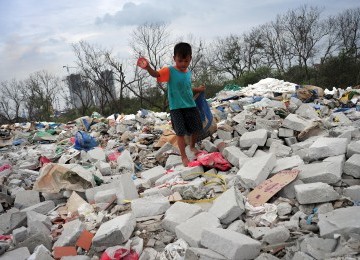 Ahmad (6), mencari sampah plastik diantara tumpukan sampah dan limbah bekas pembangunan proyek di kawasan Muara Angke, Jakarta Utara, Selasa (31/1). (Republika/Edwin Dwi Putranto)