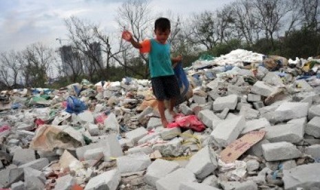 Ahmad (6), mencari sampah plastik diantara tumpukan sampah dan limbah bekas pembangunan proyek di kawasan Muara Angke, Jakarta Utara, Selasa (31/1). (Republika/Edwin Dwi Putranto)