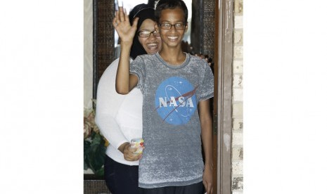 Ahmed Mohamed, 14, kanan, gelombang ke media dari pintu depan rumahnya sebagai adiknya, Eyman Mohamed, terlihat sebelum konferensi pers, Rabu 16 September, 2015, di Irving, Texas. (AP Photo / Brandon Wade)