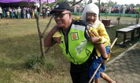 Aiptu Ato Madsoleh menggendong Ma Suti (85) menuju TPS Pilkades di Desa Gempolsari, Kecamatan Patokbeusi, Kabupaten Subang. Anggota Babhinkamtibmas  Polsek Pabuaran ini rela menggendong Ma Suti agar bisa menyalurkan hak piluhnya.