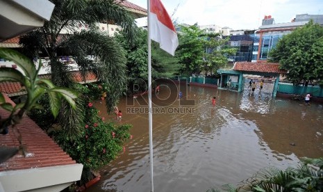 Air menggenangi halaman SD 4 Penjaringan, Jakarta Utara, Selasa (10/2). Aktifitas belajar mengajar di sekolah itu terpaksa dihentikan karena terendam banjir serta sebagian ruang kelas digunakan untuk mengungsi. 