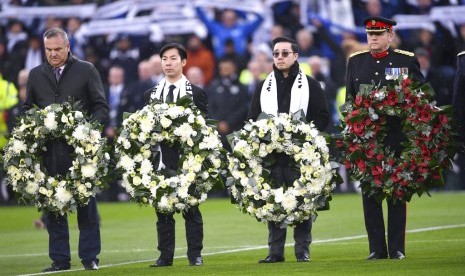 Aiyawatt Srivaddhanaprabha (kedua kanan) membawa karangan bunga untuk mengenang kematian para korban kecelakaan helikopter di Stadion King Power, termasuk ayahnya yang merupakan pemiliki Leicester City Vichai Srivaddhanaprabha, menjelang laga Lsicester vs Burnley di Leicester, Sabtu (10/11).