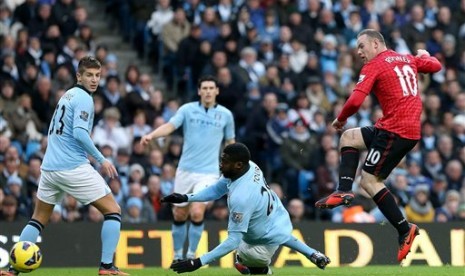 Aksi bomber Manchester United, Wayne Rooney, saat membobol gawang Manchester City pada laga Liga Primer di Etihad Stadium, Ahad (9/12) malam.