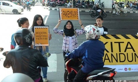 Aksi Gerakan Bandung Disiplin oleh para relawan di lampu merah di perempatan Taman Dago Cikapayang, Kota Bandung, Ahad (13/3).