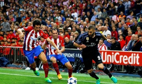 Aksi Karim Benzema (kanan) melewati para pemain Atletico Madrid.