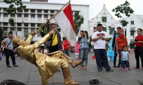 Aksi manusia patung di kawasan Kota Tua, Jakarta, menarik perhatian warga.   (foto : MgROL_37)