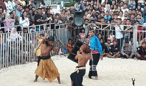 Aksi Peresean atau pertarungan antara dua lelaki yang bersenjatakan tongkat rotan dan berperisai kulit kerbau yang tebal dan keras di Pantai Kuta Mandalika, Lombok Tengah, Kamis (1/3).