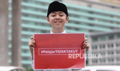 Aksi simpatik #kamitidaktakut digelar sejumlah siswa siswa SD sampai SMA di depan pos polisi bunderan HI, Jakarta Pusat, Jumat (15/1).  ( Republika/ Yasin Habibi )