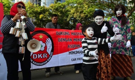 Aksi teatrikal tentang bahayanya minum susu kental manis oleh Dewan Kesehatan Rakyat (DKR) di hari bebas kendaraan Jalan MH THamrin, Jakarta, Ahad (30/7).