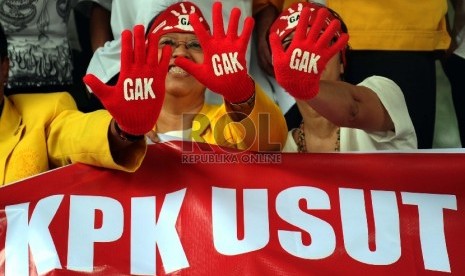 Aktifis dari Gerakan Anti Korupsi Alumni Lintas Perguruan Tinggi mengunakan sarung tangan saat aksi solidariatas di Gedung KPK, Jakarta, Jumat (27/11). (Republika/Tahta Aidilla)