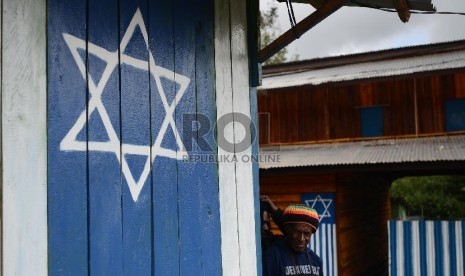   Aktifitas warga di depan rumah dengan logo Israel atau Bintang Daud di Tolikara, Papua, Jumat (24/7).    (Republika/Raisan Al Farisi)