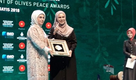 Aktivis dan relawan Muslimah Medical Emergency Rescue Committee (Mer-C) Nur Fitri Taher (kanan) menerima penghargaan dari International Mount of Olive Peace Awards yang diserahkan Ibu Negara Turki Emine Erdogan, Senin (7/5) di Istanbul, Turki.