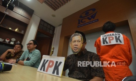 Aktivis koalisi masyarakat sipil melakukan teatrikal dengan menggunakan topeng Wakil Ketua DPR Fahri Hamzah yang tengah memukul palu saat menggelar konferensi pers di Kantor Indonesia Corruption Watch (ICW), Jakarta, Rabu (3/5). D