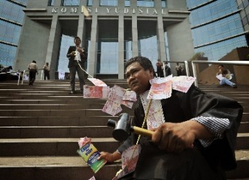 Aktivis melakukan aksi teatrikal mengkritik kasus penyuapan hakim di depan gedung Komisi Yudisial (KY), Jakarta.