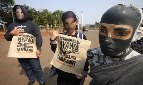 Aktivis melakukan teatrikal saat menggelar Aksi Solidaritas untuk Salim Kancil dan Tosan di depan Istana Negara, Jakarta, Kamis (1/10). 