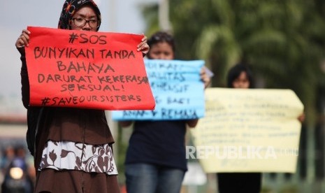 Aktivis membentangkan poster saat melakukan aksi gerakan Save Our Sister (SOS) di depan Kompleks Parlemen, Senayan, Jakarta.