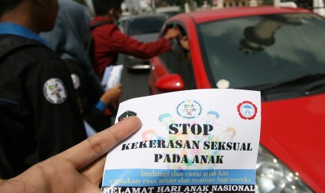 Aktivis perlindungan anak berorasi dan membagikan stiker Anti Kekerasan Seksual Pada Anak dalam rangka memperingati Hari Anak Nasional di Alun-Alun Kota Kediri, Jawa Timur, Kamis (23/7).