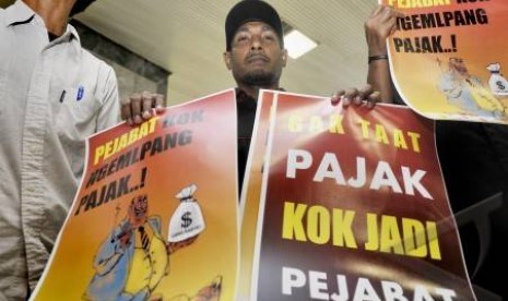 Aktivis yang tergabung dalam Forum Masyarakat Peduli Keadilan (FMPK) membawa poster anti korupsi pajak di Kompleks DPR-RI Senayan, Jakarta.