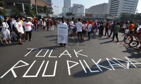 Aktivis yang tergabung dalam Koalisi Kawal RUU Pilkada melakukan aksi tolak RUU Pilkada di kawasan Bundaran Hotel Indonesia, Jakarta, Ahad (14/9).  (Republika/ Tahta Aidilla)