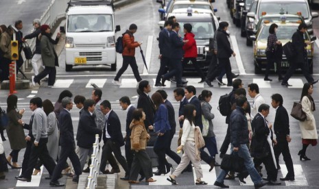 Aktivitas pekerja Jepang di salah satu jalanan Kota Tokyo. Bank of Japan (BOJ) memproyeksi inflasi konsumen inti kemungkinan akan mulai melambat akhir tahun ini karena efek dari lonjakan biaya bahan baku pada masa lalu mulai menghilang.