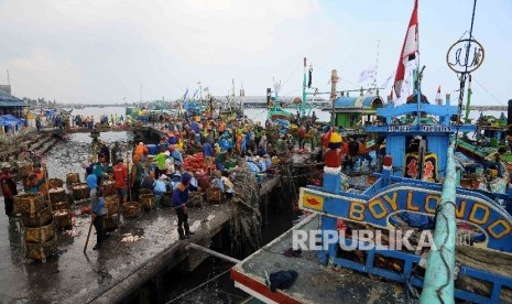 Aktivitas pekerja membongkar muat ikan hasil tangkapan nelayan di Tempat Palelangan Ikan (TPI) Brondong, Lamongan, Jawa Timur, Kamis (6/10)