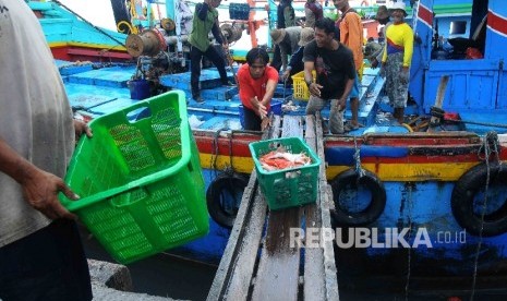 Aktivitas pekerja membongkar muat ikan hasil tangkapan nelayan di Tempat Palelangan Ikan (TPI) Brondong, Lamongan, Jawa Timur, Kamis (6/10)